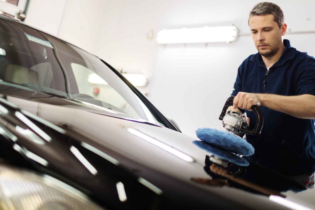 Man on a car wash polishing car with a polish machine